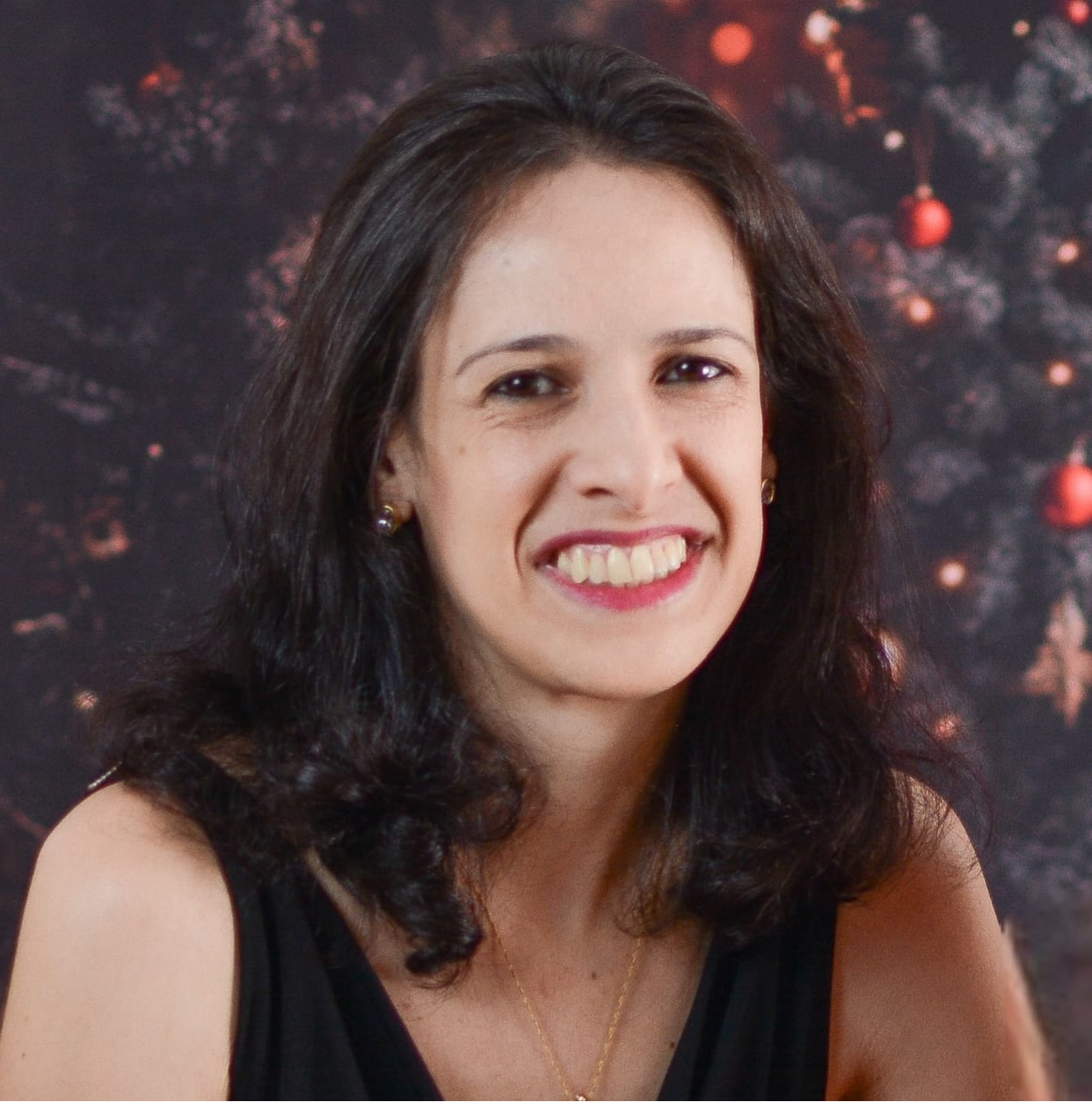 foto de Fernanda Casciatori com cabelos longos e castanhos, sorrindo e olhando diretamente para a câmera.
